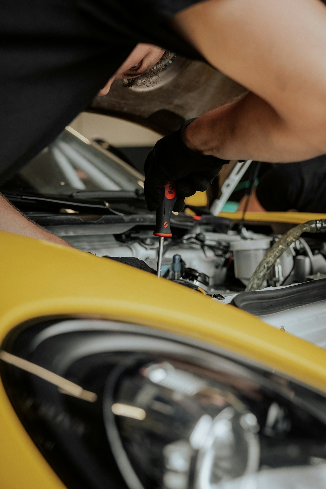 a-mechanic-is-working-on-a-yellow-car-wyeoo5vgfz8