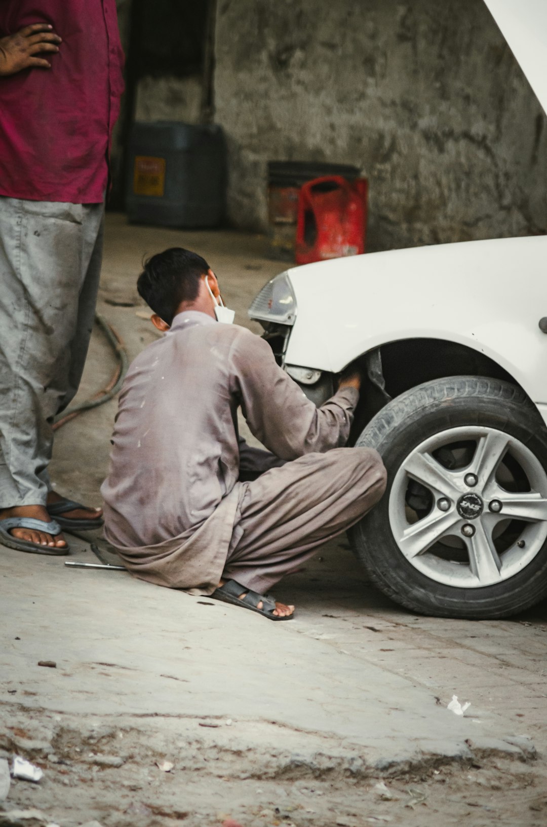 A child working in a Car Repairing Workshop.