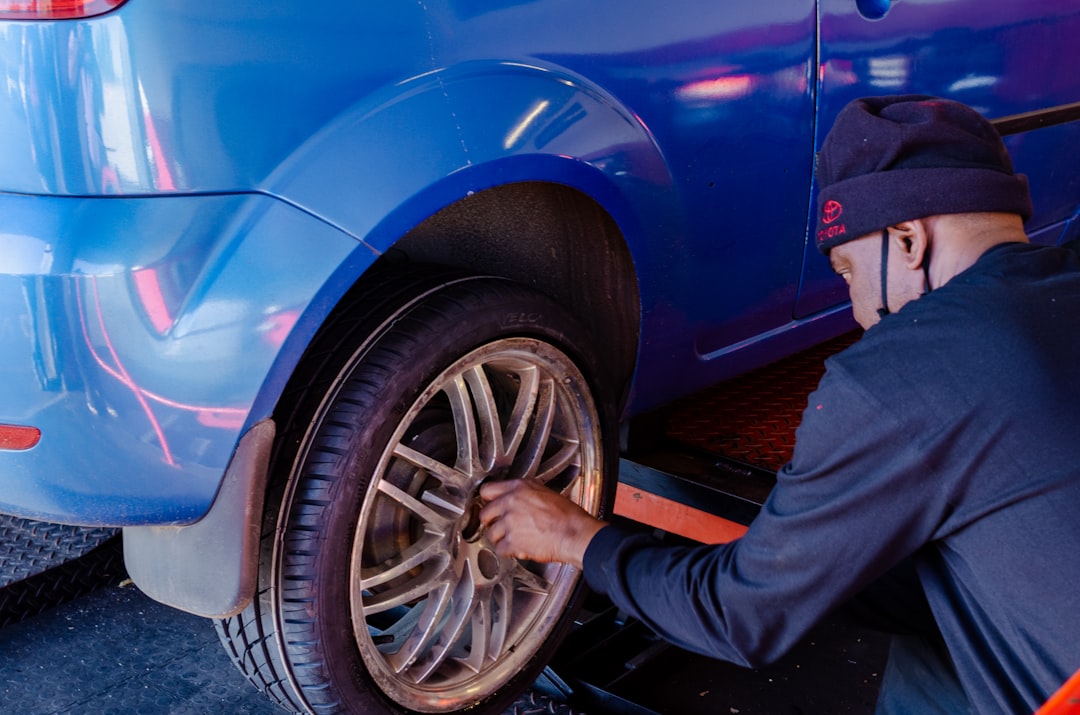 person-in-black-pants-standing-beside-blue-car-leylkgdxvvm